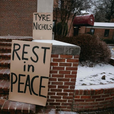 På två skyltar vid en trappa står det "Tyre Nichols" och "Rest in Peace" (Vila i frid). På marken intill finns ett tunt lager snö.