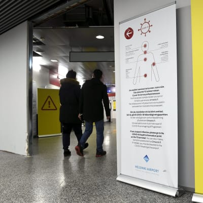 Koronaohjeistusta ja lentomatkustajia Helsinki-Vantaan lentokentällä.