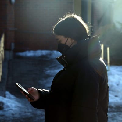 Ukrainalainen Daria puhelin kädessä ulkona. Darian on muutettu hänen turvallisuutensa suojelemiseksi.