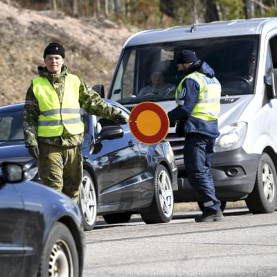 En beväring visar stopptecken för en bil.