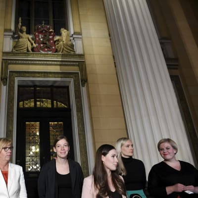 Ministrarna Matti Vanhanen (till vänster), Anna-Maja Henriksson, Li Andersson, statsminister Sanna Marin, inrikesminister Maria Ohisalo och Annika Saarikko står på Ständerhusets trappa i Helsingfors.