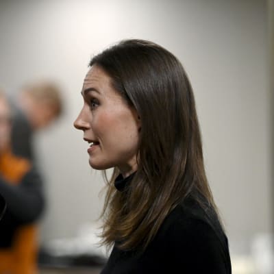 Sanna Marin fotograferad från sidan medan hon talar med journalister.