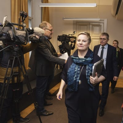 Riksförlikningsman Anu Sajavaara och KT:s verkställande direktör Markku Jalonen omgivna av journalister på riksförlikningsmannens byrå i Helsingfors.