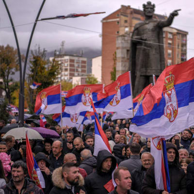 Kosovoserber viftar med serbiska flaggor under en protest i den serbiska dominerande delen av Mitrovica.