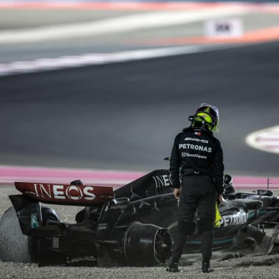 Lewis Hamilton står vid sin bil.