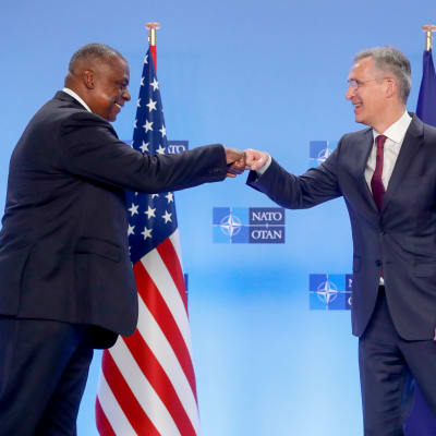 Naton pääsihteeri ja Yhdysvaltain puolustusministerit tekevät nyrkkitervehdyksen tiedotustilaisuudessa.