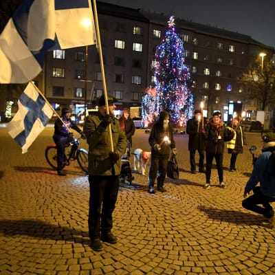 Bild på personer som samlats på torg med finlands flagga.