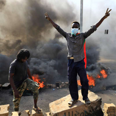 Unga sudanesiska demonstranter blockerade gator i Khartoum med brinnande bildäck. 
