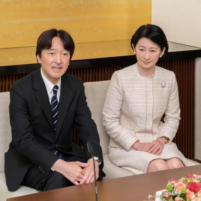 Kronprins Akishino och kronprinsessan Kiko sitter ner på två stolar, han i kostym, hon i ljus klänning. 