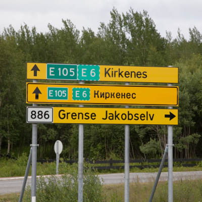 En gul vägskylt med Kirkenes i latinska och kyrilliska bokstäver.