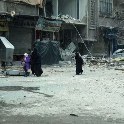 Syriska kvinnor söker skydd då staden Douma i östra Ghouta bombas 10.3.2018. 