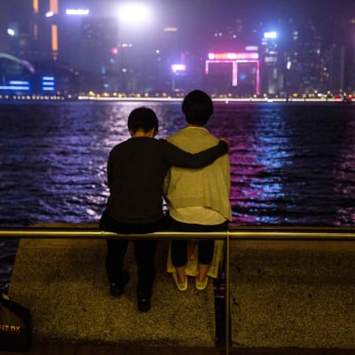 Ett par tittar ut över hamnen i Victoria Harbour i Hongkong 21.3.2020