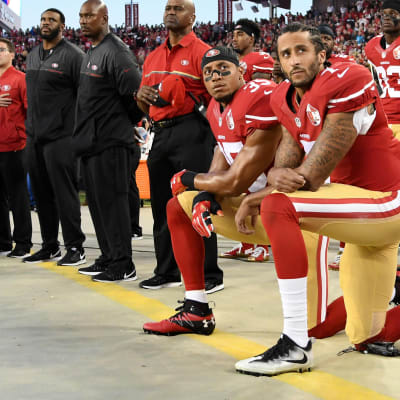 Colin Kaepernick  och Eric Reid knäböjer i protest då nationalsången spelas 