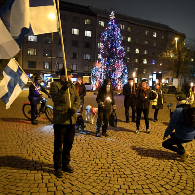 Bild på personer som samlats på torg med finlands flagga.
