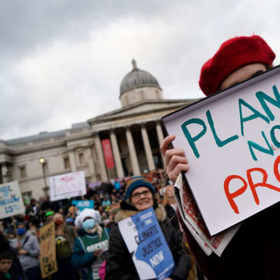 En person bär en skylt med texten "Planet not profit" (planeten, inte vinsten) på Trafalgar Square i London under en demonstration den 6 november 2021.