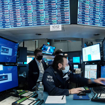 Börsproffs arbetar vid New York-börsen omgivna av många datorskärmar den 18 januari 2022. 