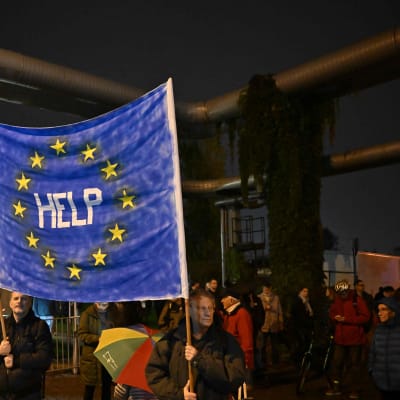 Demonstranter håller i en banderoll med EU-flaggan med texten "Hjälp" under en demonstration för oberoende nyheter i Ungern. 