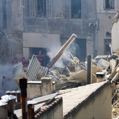 Räddningspersonal arbetar i rasmassorna efter att ett bostadshus kollapsade i Marseille i Frankrike den 9 april 2023.