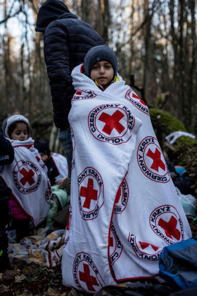 En pojke från en kurdisk familj från Irak sveper in sig i Röda korsets filt i en skog i väntan på att familjen ska föras till staden Narewka i Polen. 