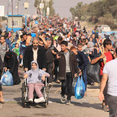 Palestiinalaiset kantavat omaisuuttaan, kun perheet pakenevat Gazan kaupungista.
