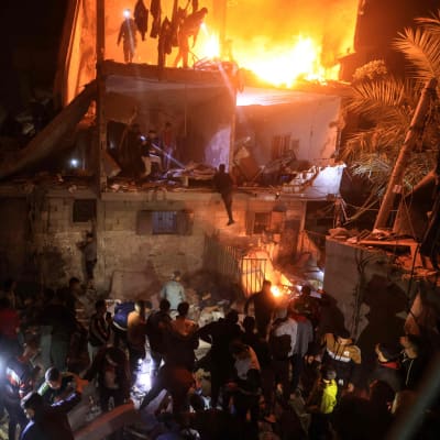 Människor i Rafah, i södra Gaza, letade efter offer i ett brinnande hus på onsdag kväll. den 6 december. 
