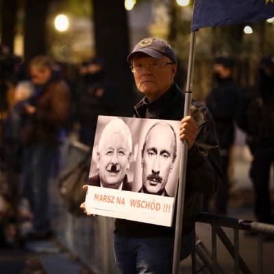 Puolan korkeimman oikeuden edustalle kokoontui torstai-iltana joukko mielenosoittajia. Mies piti kädessään kylttiä, jossa Venäjän presidentti Vladimir Putin ja valtapuolue PiSin johtaja Jaroslaw Kaczynski esiettiin diktaattoreina.