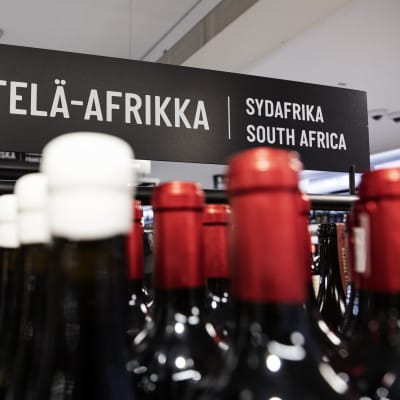 Viinejä Alkon myymälässä Helsingissä. Taustalla kyltti, jossa kerrotaan viinien alkuperämaa Etelä-Afrikka.
