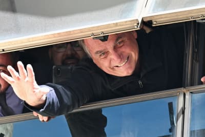 Jair Bolsonaro vinkar i ett fönster.