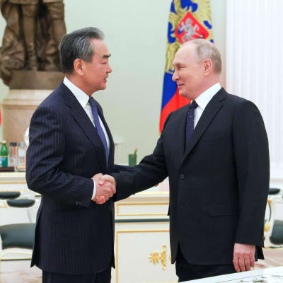 Wang Yi ja Vladimir Putin kättelevät. 