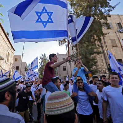 Israelilaisjoukko heiluttaa Israelin lippuja.
