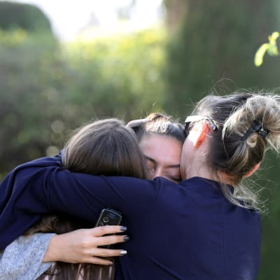Ungdomar håller om varandra nära gymnasieskolan i Grasse där en 17-årig pojke började skjuta omkring sig den 16 mars 2017.