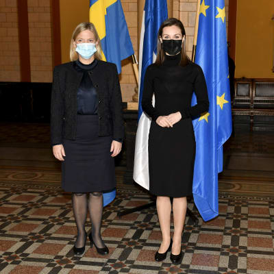 Magdalena Andersson och Sanna Marin i Ständerhuset framför Sveriges, Finlands och EU:s flaggor.