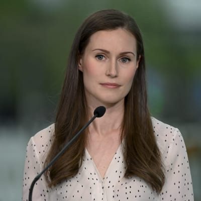 Sanna Marin i vitprickig skjorta.