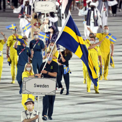 Svenska idrottare tågar in på arenan. 