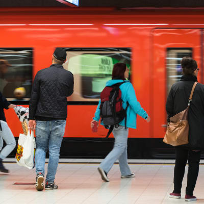Ihmisiä astumassa metrojunaan, metro Helsingin Rautatieasema