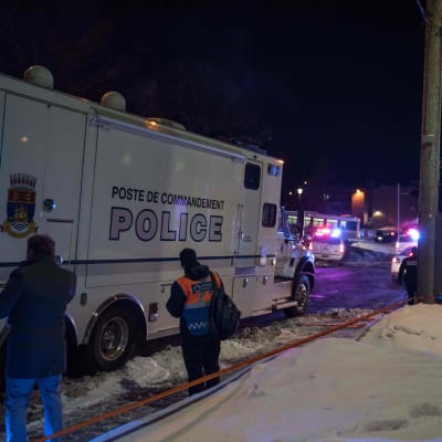 En polisbil och i bakgrunden flera räddningsfordon utanför en moské i Quebec, Kanada, där fem personer uppges ha dött i en skjutning.