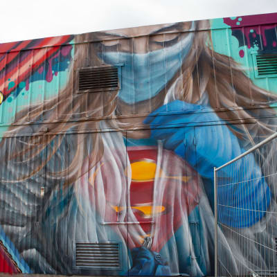Sairaanhoitaja Superman -seinämaalausteos Konepajalla.