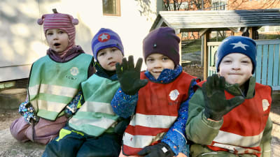 Fyra barn utomhus på en bergsknalle.