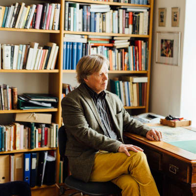 Författaren och filosofen Fredrik Lång sitter vid ett skrivbord.