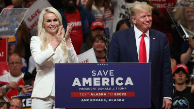 Donald Trump i blå kostym och en kvinna i vitt.