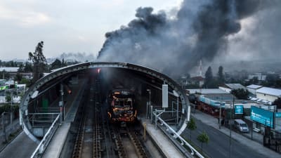 En brinnande metrostation fotograferad i Santiago på lördagen. 