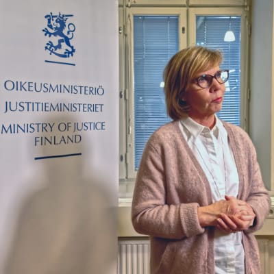 Justitieminister Anna-Maja Henriksson framför en plansch där det står Justitieministeriet. 