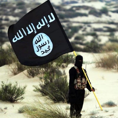 Naamioitu mies pitää kädessään Isisin lippua.