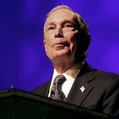 Närbild på Michael Bloomberg mot blå bakgrund.