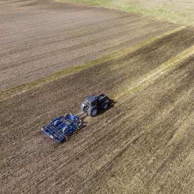 Traktori ajaa pellolla.