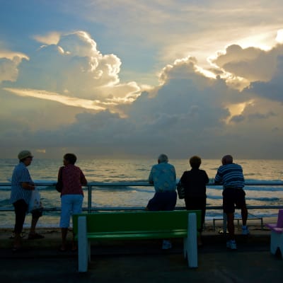 Pensionärer i Florida tittar på solnedgången i Lake Worth.