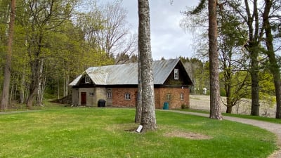 En brun ladugård i sten.