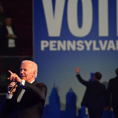 Joe Biden med mikrofon på en kampanjscen.