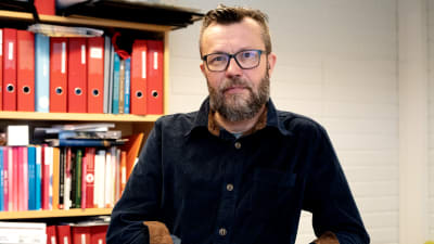 Rektor för Kyrkslätts gymnasium Mikael Eriksson. Han är vit, har ljusbrunt hår, grått skägg, mörka ögon och glasögon.