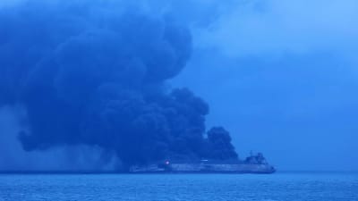 Tankfartyg brinner på havet utanför Shanghai. Tjock svart rök stiger från båten.